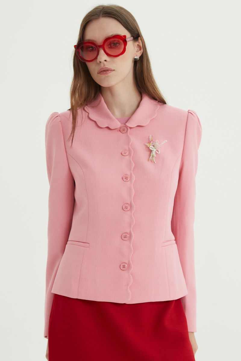 Blazer rosa sastrero entallado con terminación ondulada y mangas princesa. 
