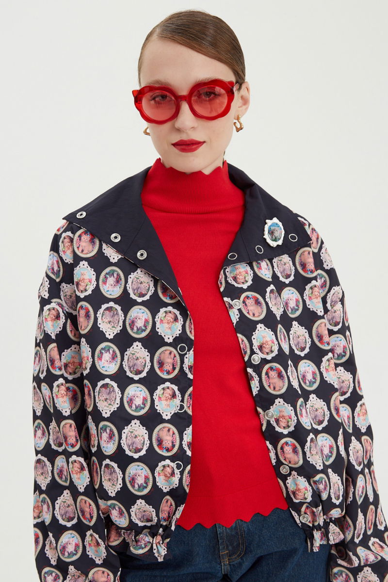 Campera reversible con puntilla y estampado de gatitos, cuello alto, broches snap y cintura con tancas.