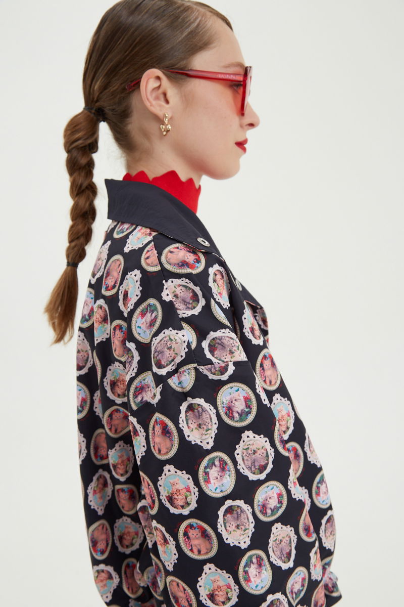 Campera reversible con puntilla y estampado de gatitos, cuello alto, broches snap y cintura con tancas.