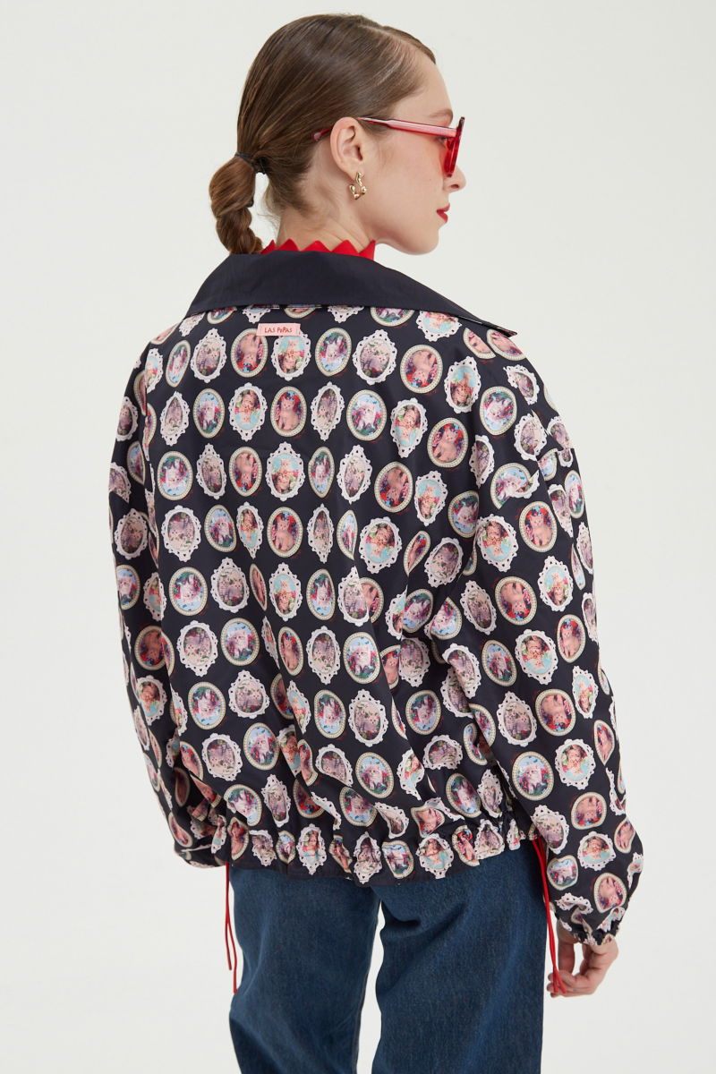 Campera reversible con puntilla y estampado de gatitos, cuello alto, broches snap y cintura con tancas.