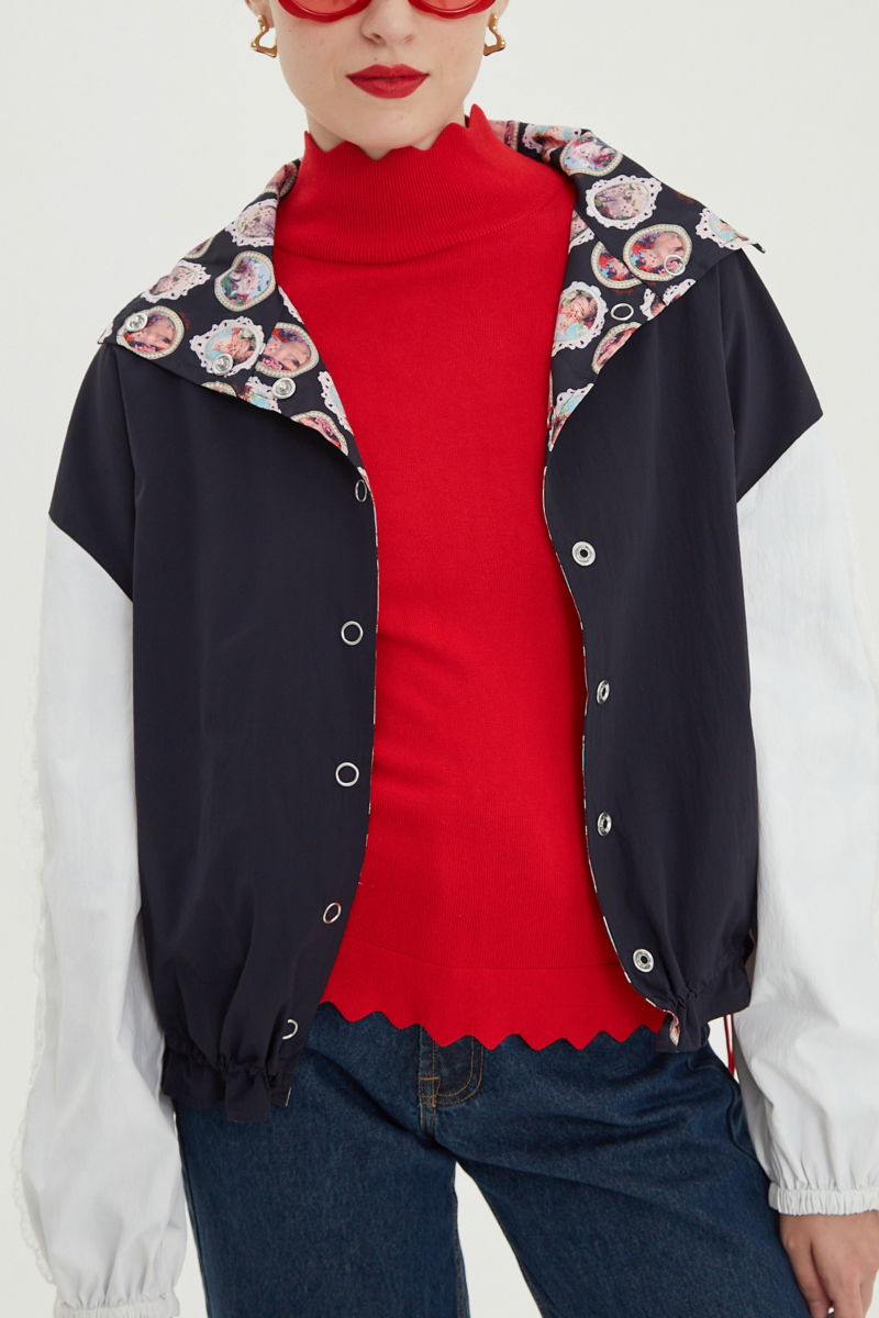 Campera reversible con puntilla y estampado de gatitos, cuello alto, broches snap y cintura con tancas.