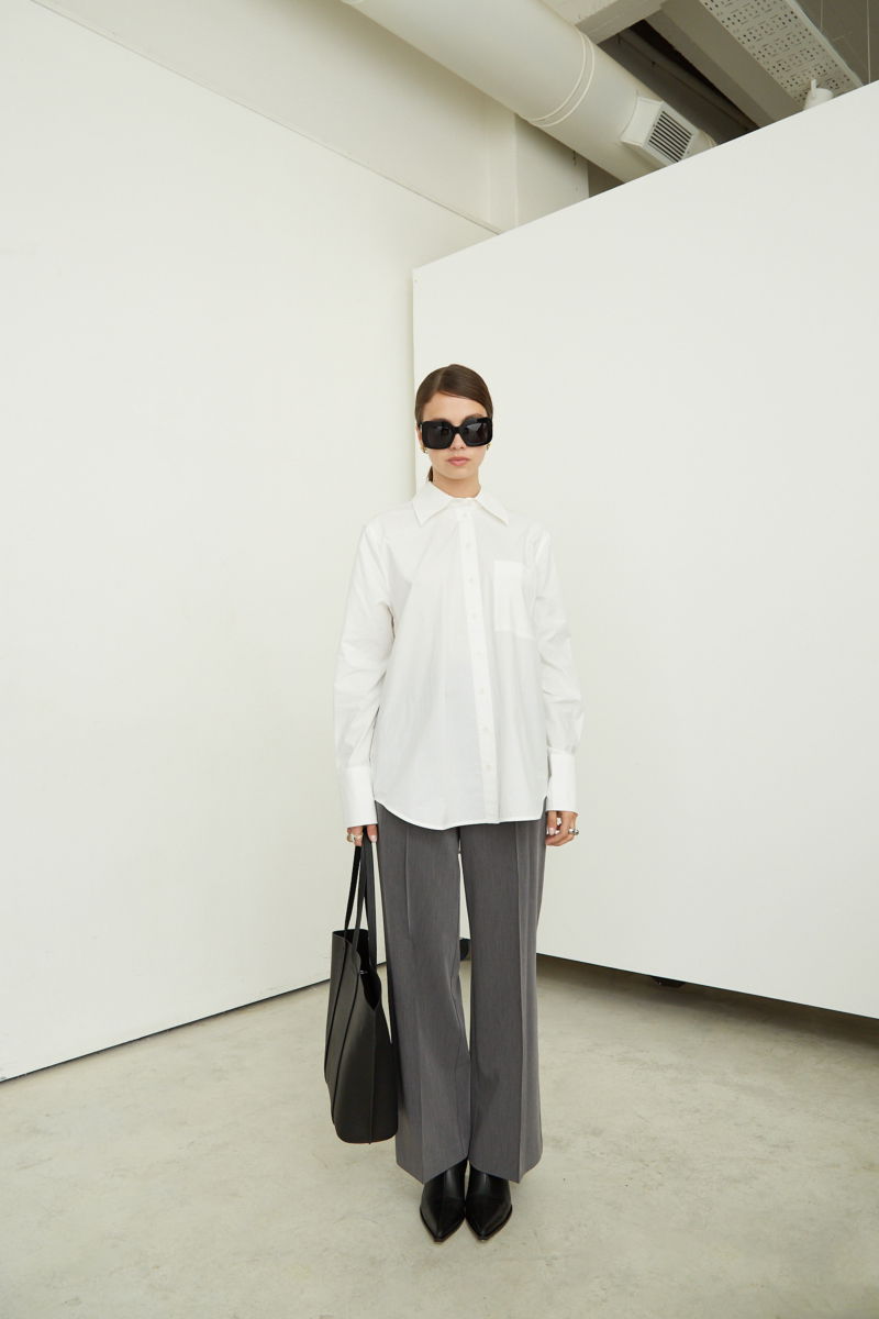 Camisa blanca oversize de poplín de algodón larga por debajo de la cadera con bolsillo aplicado al frente, tabla en la espalda y botones a tono.