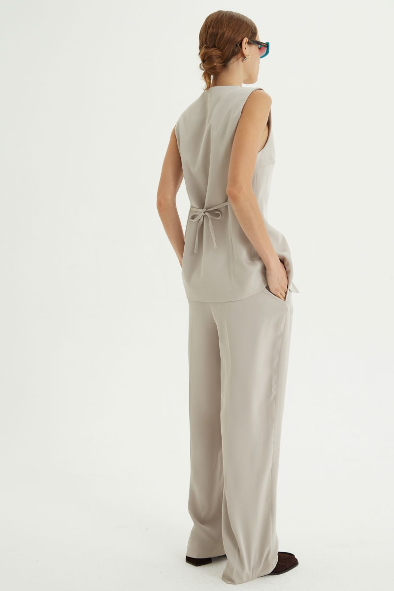 Pantalón beige sastrero tiro alto recto y largo a los tobillos con cintura con elástico y lazo a tono para atar. 