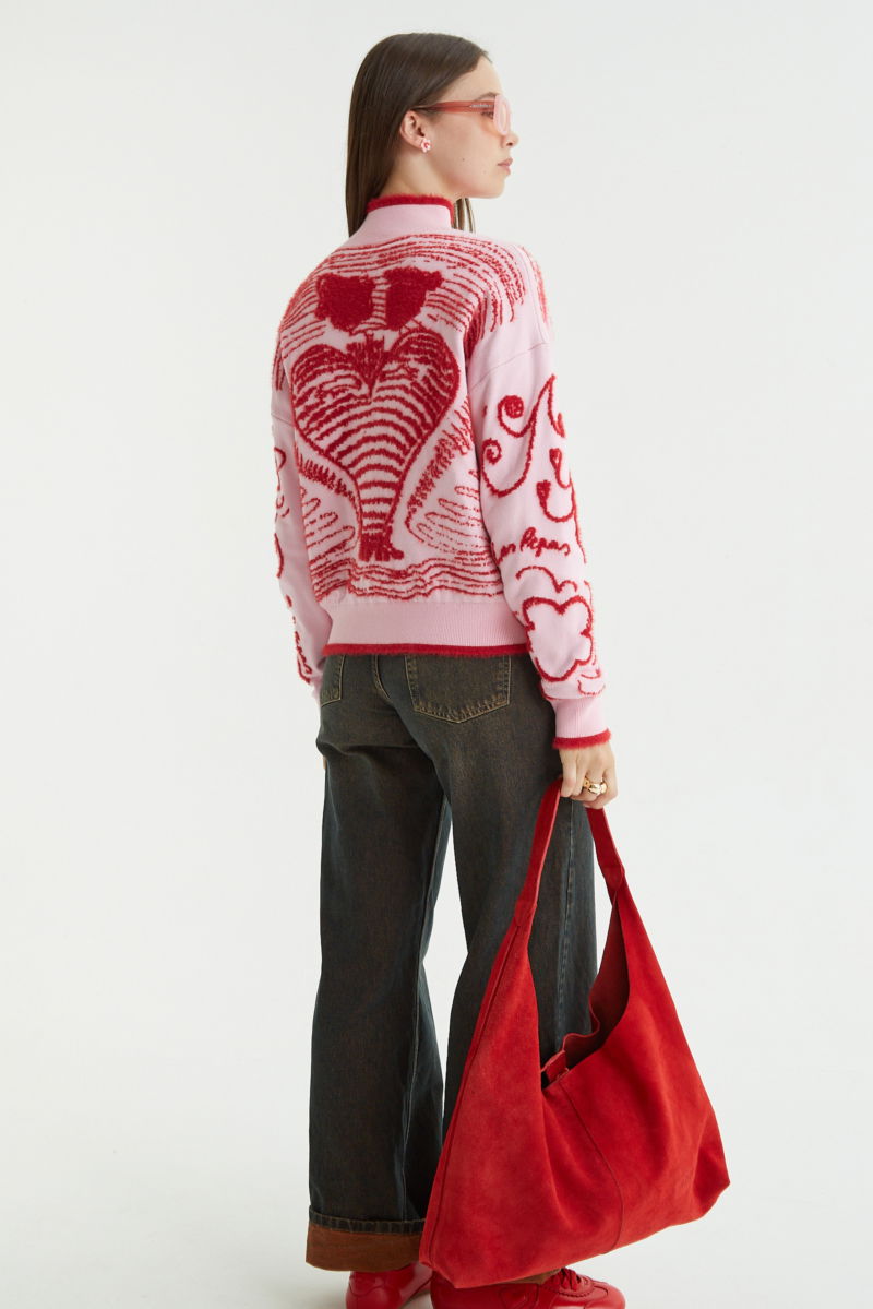 Maxi cartera roja de gamuza con broche con imán, logo de Las Pepas en el frente y bolso interno de red desmontable. 