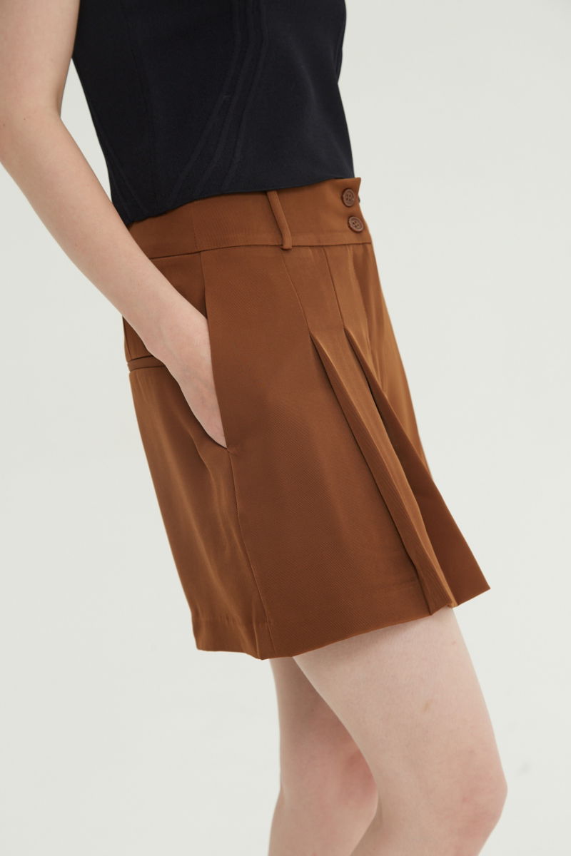 Short suela sastrero con pinzas delanteras, cintura ancha con presillas para cinturón y botones a tono, bolsillos laterales y bolsillos ojal traseros.
