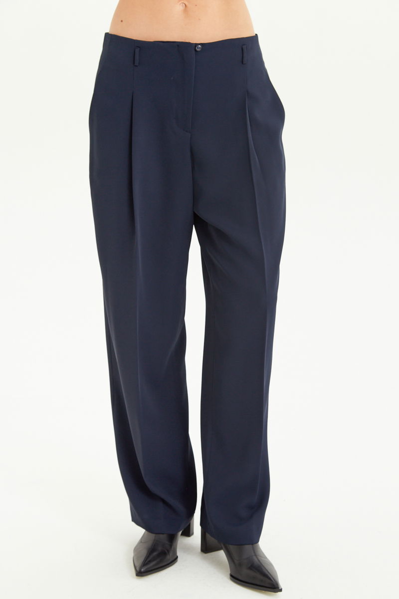 Pantalón azul sastrero tiro alto, de corte recto y largo hasta los tobillos con pinzas de entalle en frente y espalda. 
