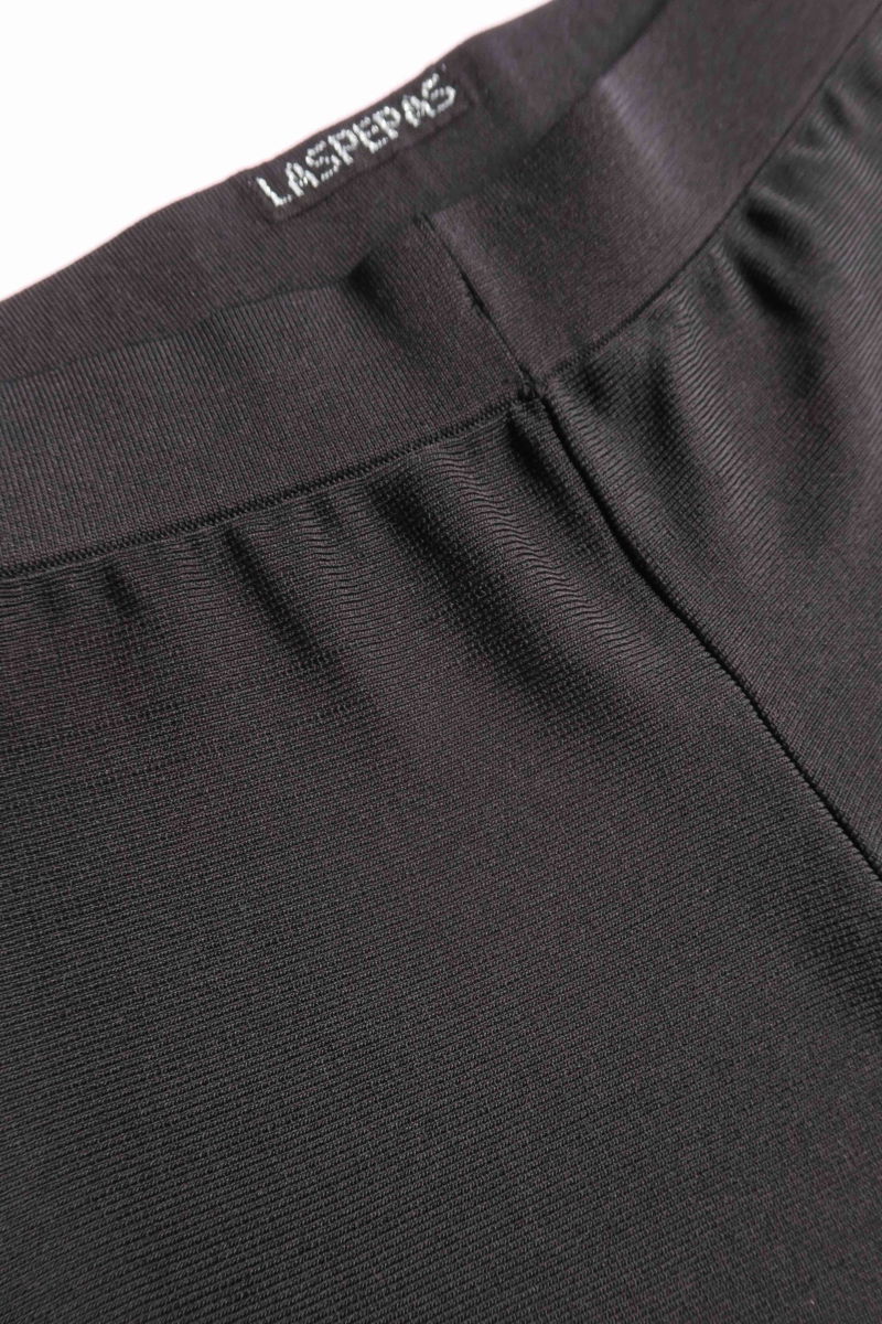 Pantalón negro tejido tiro alto y de calce recto con cintura elástica, piernas anchas y largo por arriba de los tobillos. 