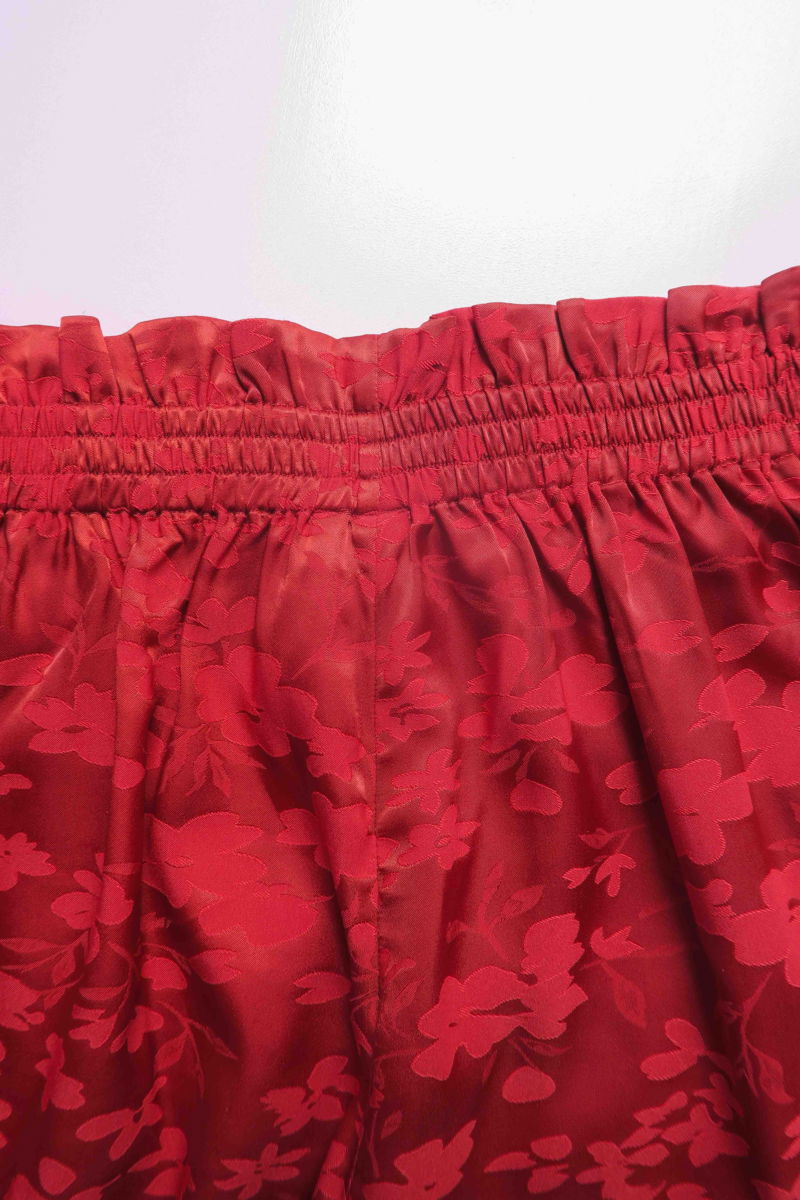 Pantalón rojo amplio tiro alto satinado de jacquard con motivo floral y cintura elastizada con pliegues.
