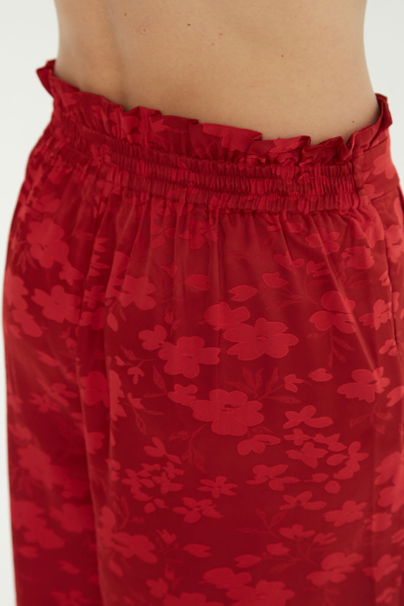 Pantalón rojo amplio tiro alto satinado de jacquard con motivo floral y cintura elastizada con pliegues.
