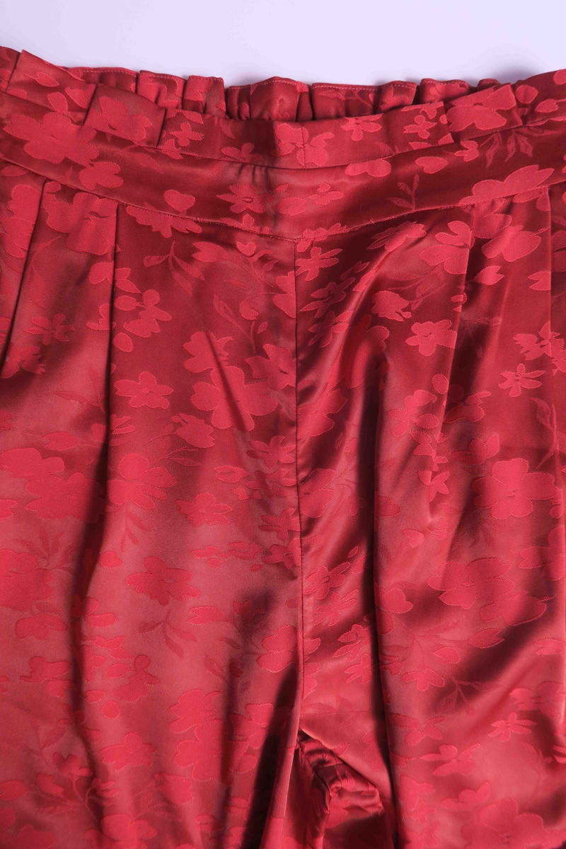 Pantalón rojo amplio tiro alto satinado de jacquard con motivo floral y cintura elastizada con pliegues.
