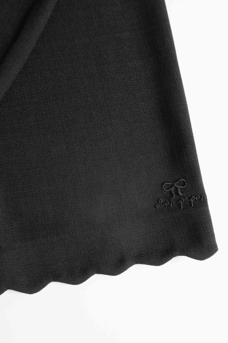 Pantalón negro sastrero recto tiro medio con terminación ondulada en el ruedo.
