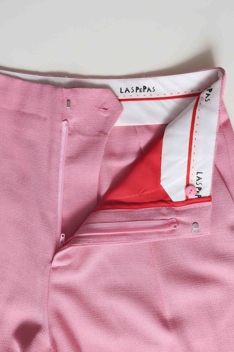 Pantalón rosa sastrero recto tiro medio con terminación ondulada en el ruedo.
