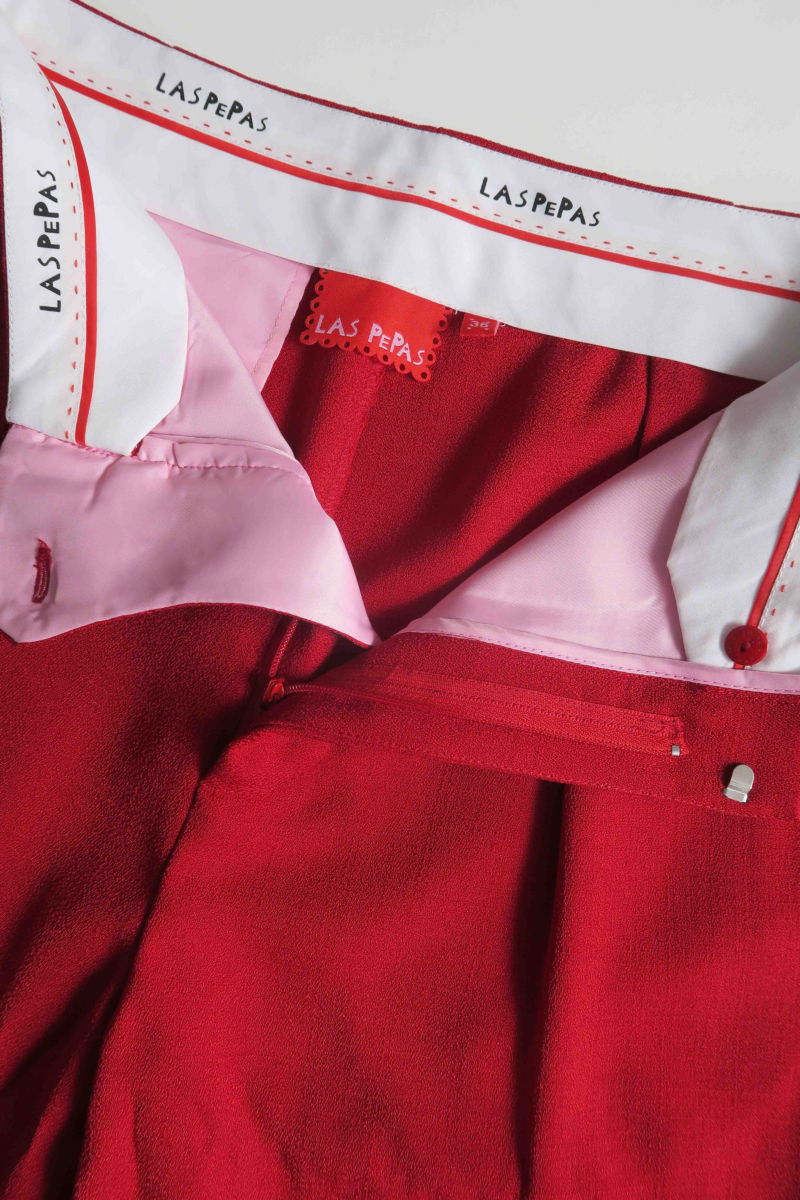 Pantalón rojo sastrero recto tiro medio con terminación ondulada en el ruedo.
