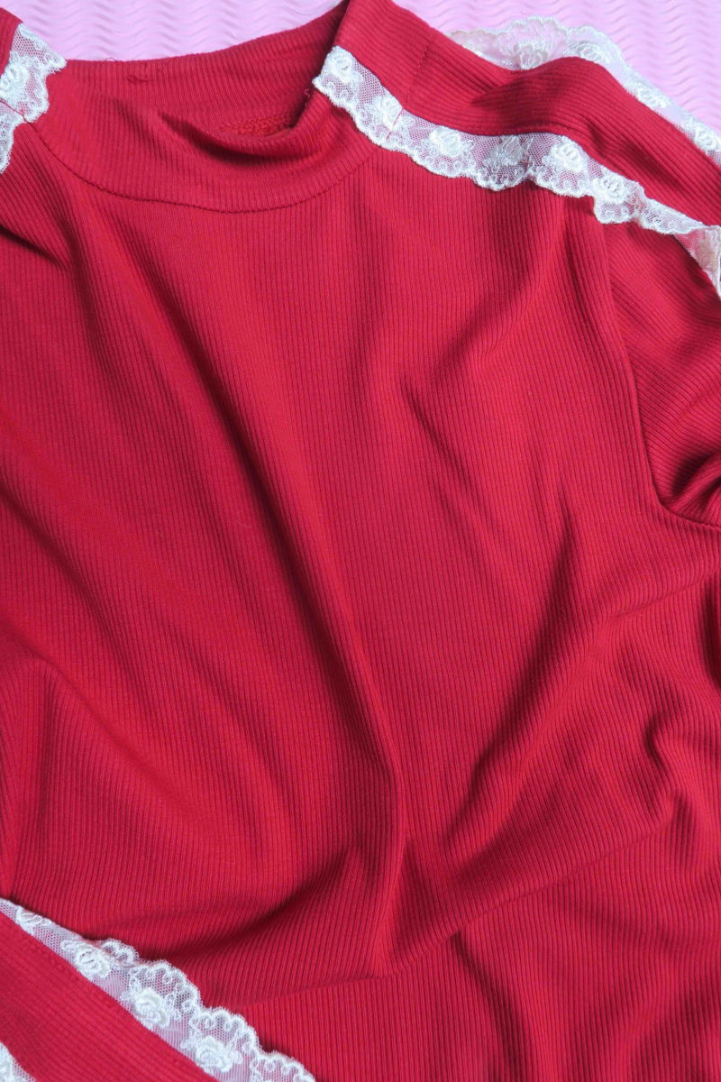 Polera roja de morley al cuerpo y larga a la cadera con cuello media polera y puntilla en cuello y mangas. 

