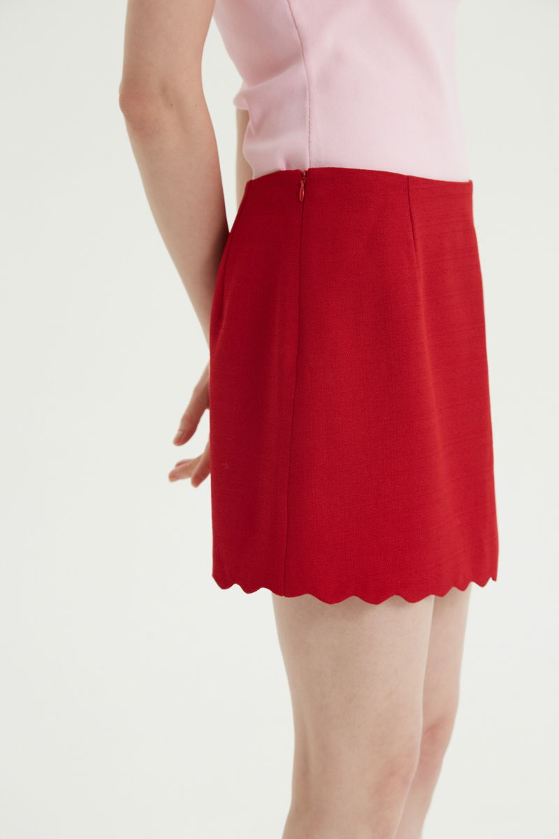 Mini falda rojo sastrera tiro medio de silueta recta con terminación ondulada en el ruedo. 
