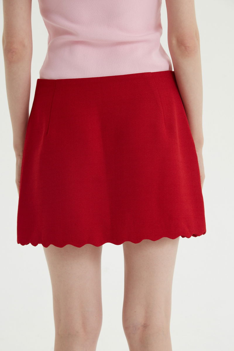 Mini falda rojo sastrera tiro medio de silueta recta con terminación ondulada en el ruedo. 
