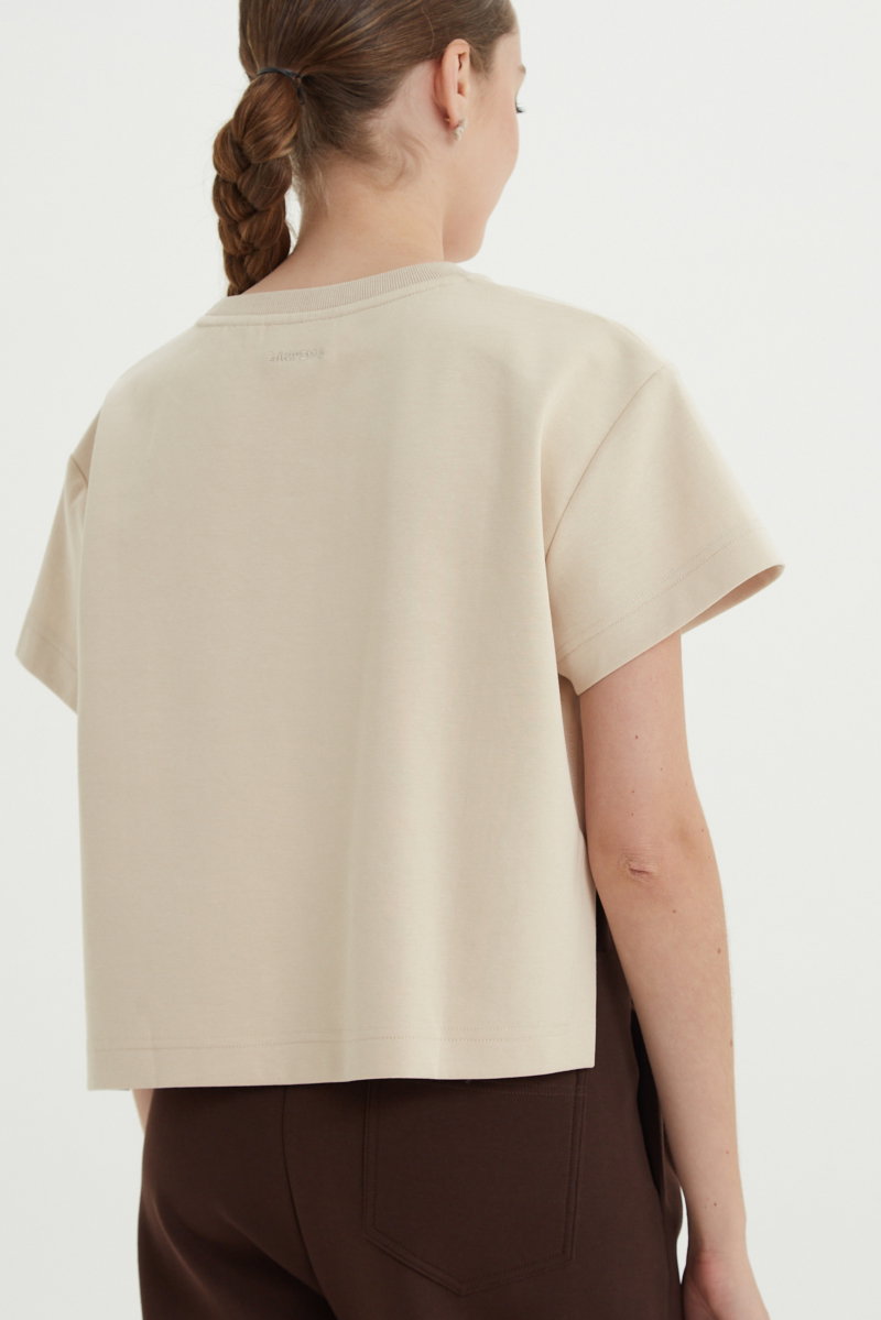 Remera beige crop de algodón recta, de mangas cortas y cuello redondo. 