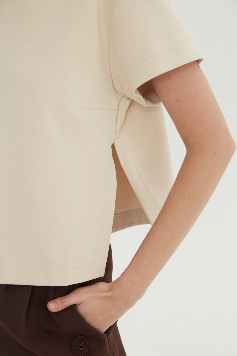 Remera beige crop de algodón recta, de mangas cortas y cuello redondo. 