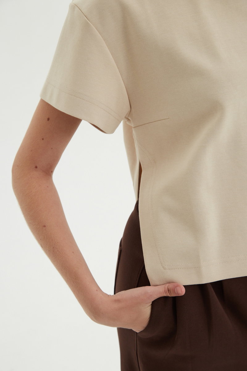 Remera beige crop de algodón recta, de mangas cortas y cuello redondo. 