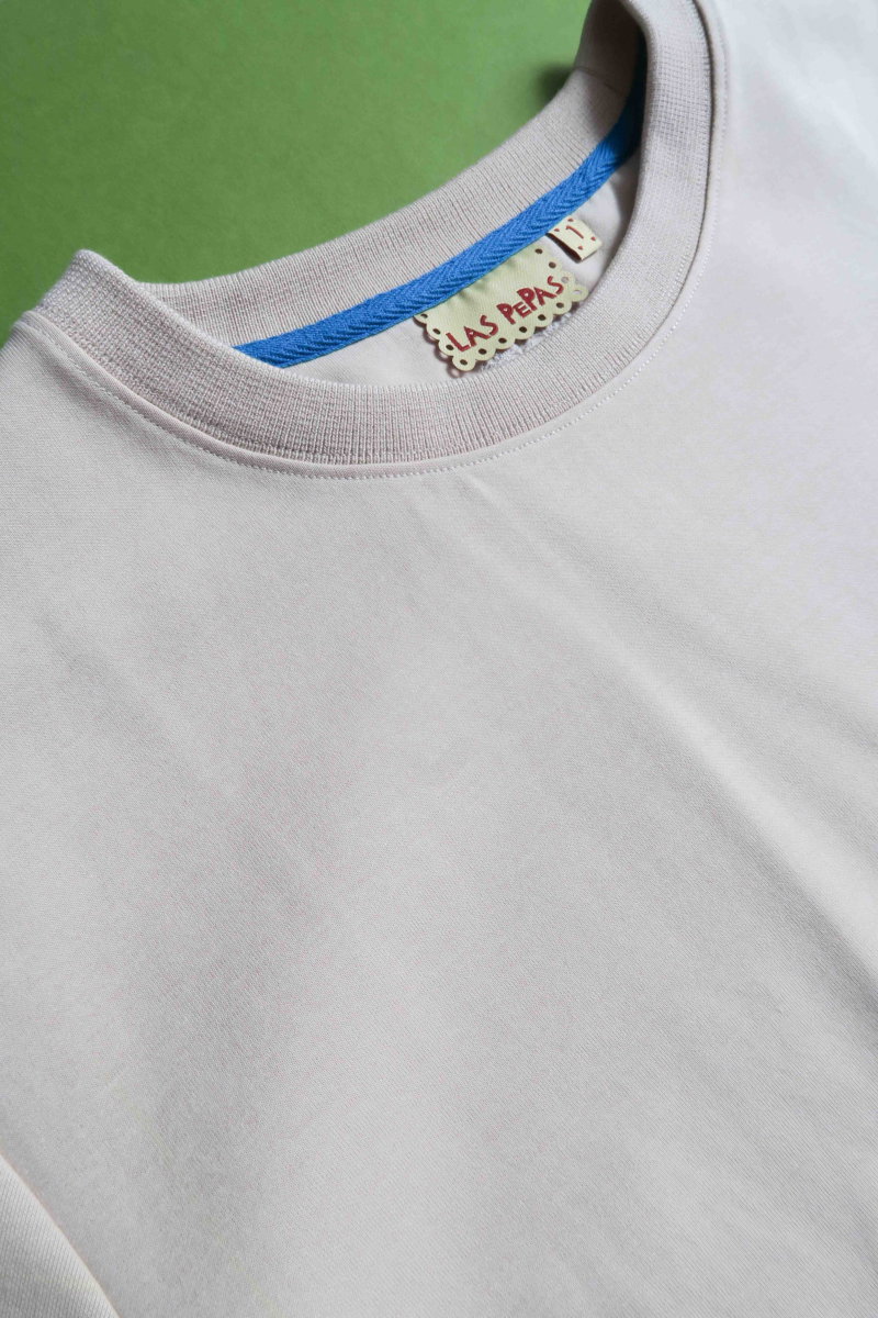 Remera beige crop de algodón recta, de mangas cortas y cuello redondo. 