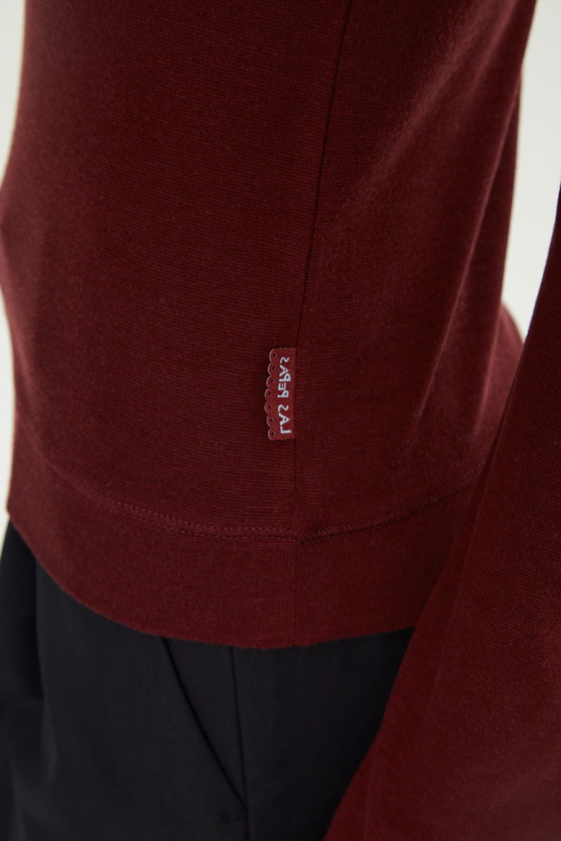 Remera bordo manga larga raglán de corte recto y larga a la cadera con cuello redondo y ruedo ancho. 
