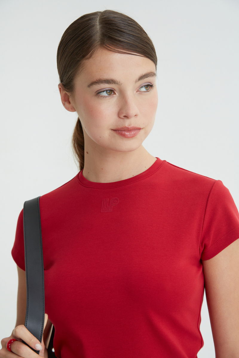 Remera rojo manga corta de algodón elastizado al cuerpo, larga a la cintura y de cuello redondo con logo LP en vinilo velvet en el frente. 
