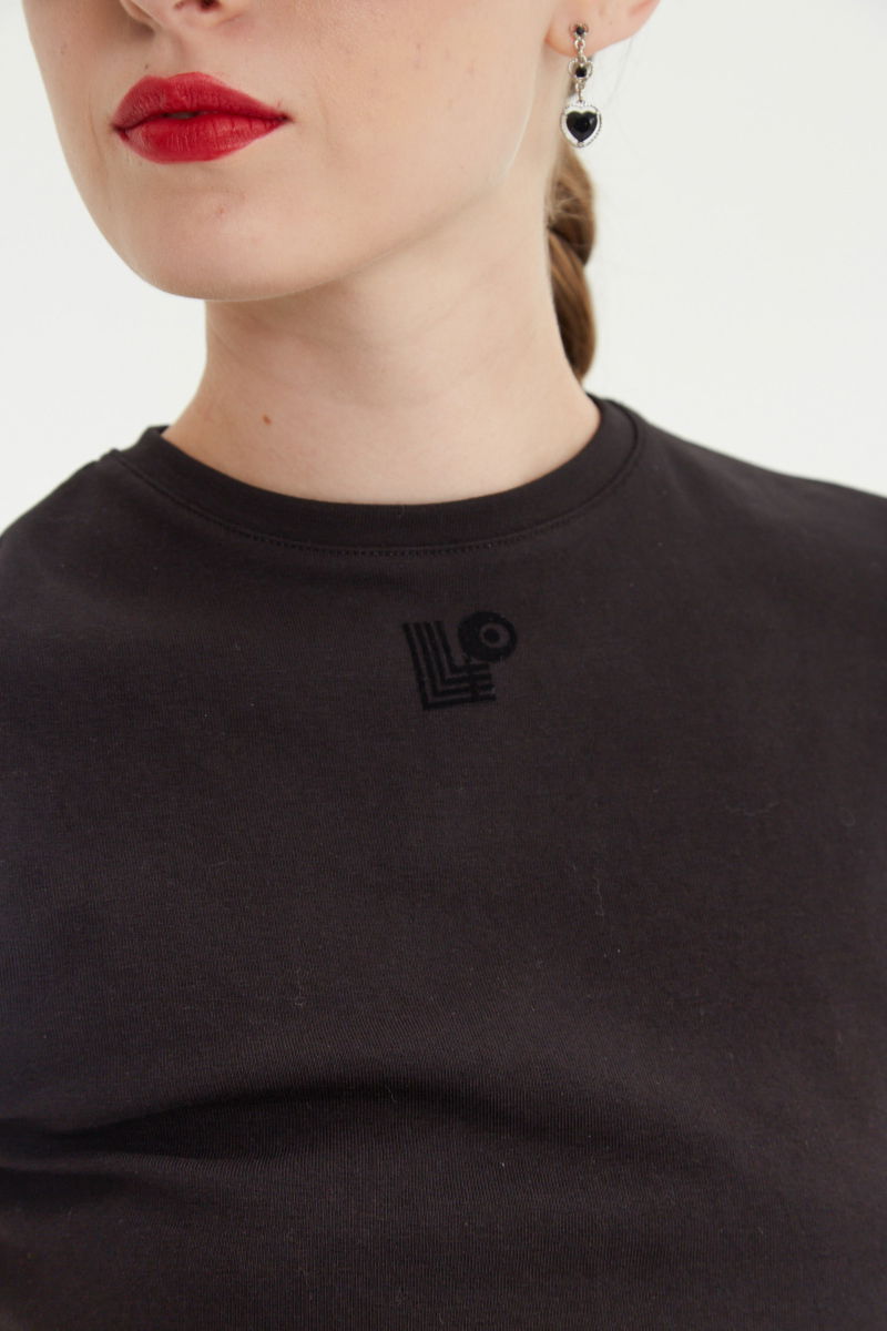 Remera negra manga corta de algodón elastizado al cuerpo, larga a la cintura y de cuello redondo con logo LP en vinilo velvet en el frente. 

