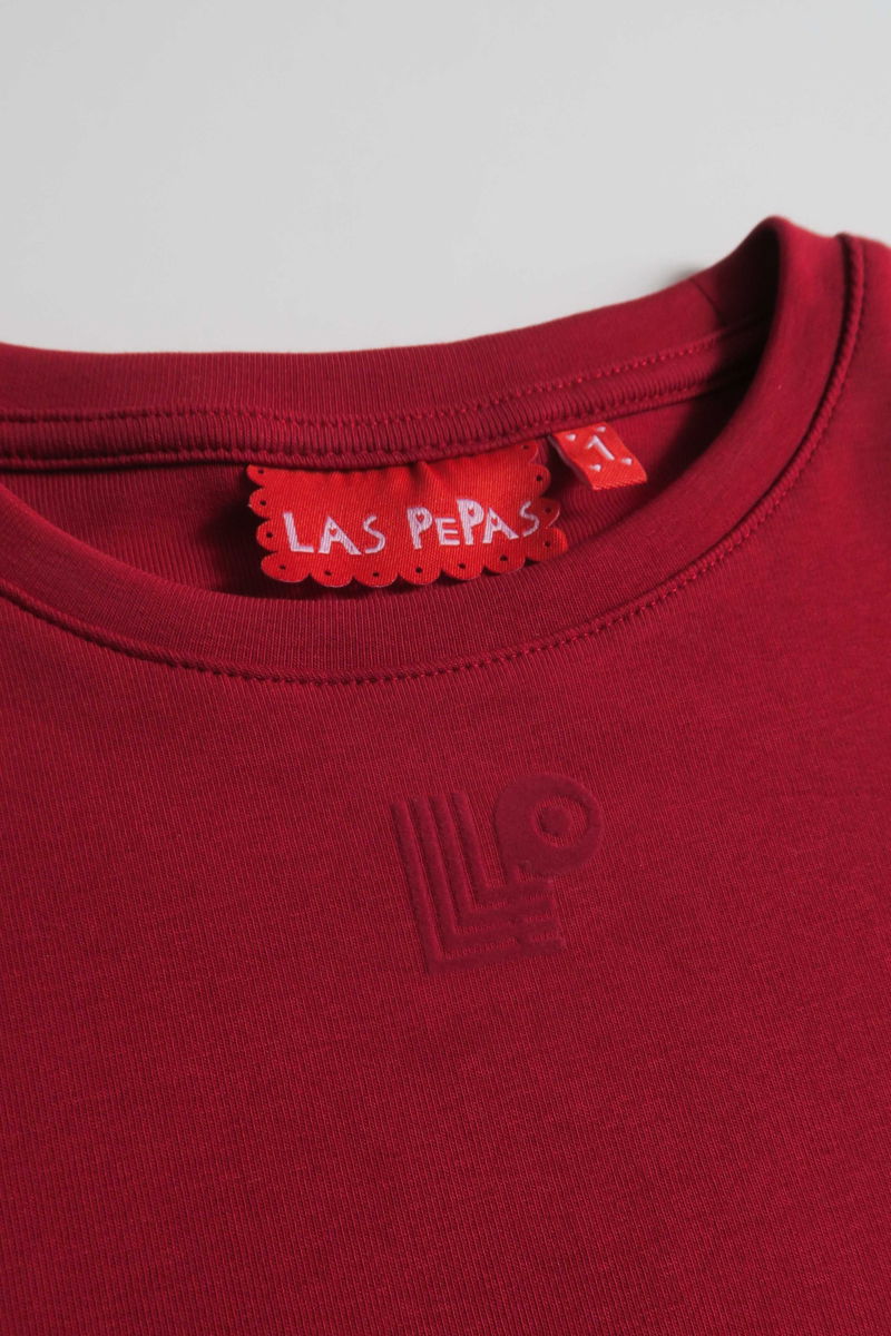 Remera rojo manga corta de algodón elastizado al cuerpo, larga a la cintura y de cuello redondo con logo LP en vinilo velvet en el frente. 
