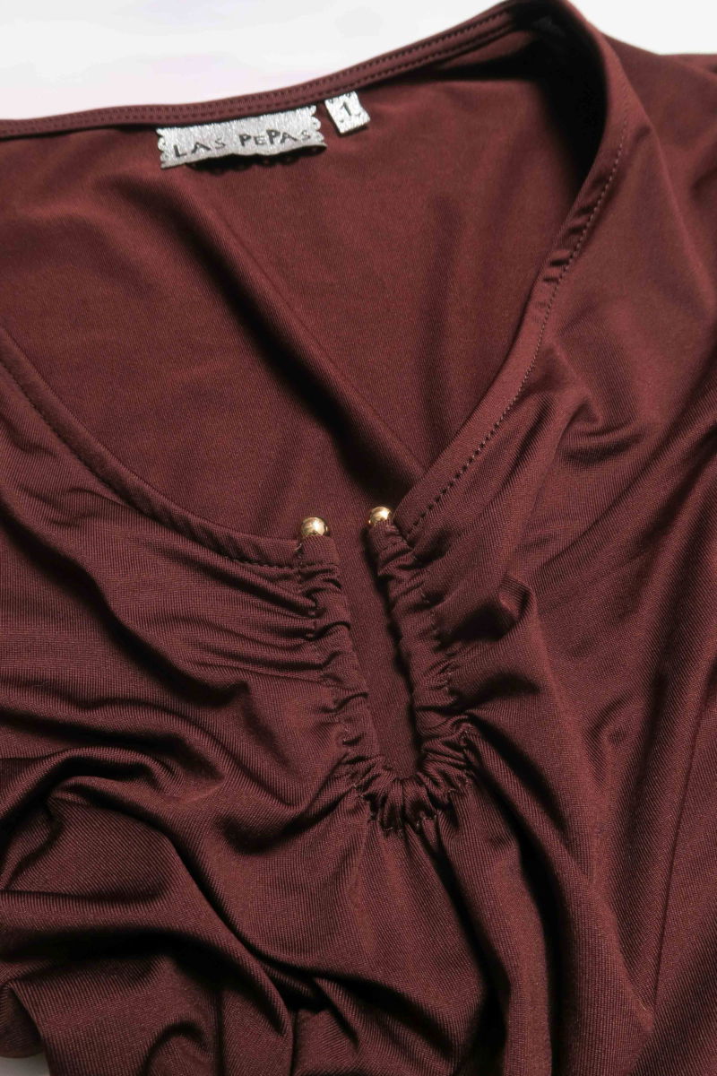 Remera marron manga larga de calce al cuerpo larga a la cadera con escote bajo con avio metalico en forma de U. 
