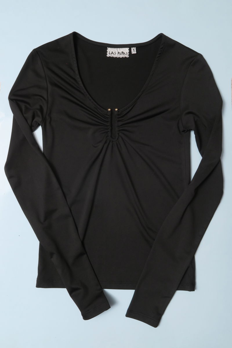 Remera negra manga larga de calce al cuerpo larga a la cadera con escote bajo con avio metalico en forma de U. 
