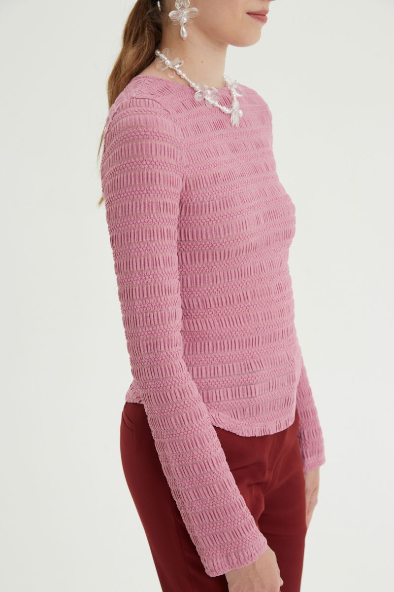 Remera rosa al cuerpo con mangas semi acampanadas, con escote a la base del cuello y textura fruncida. 
