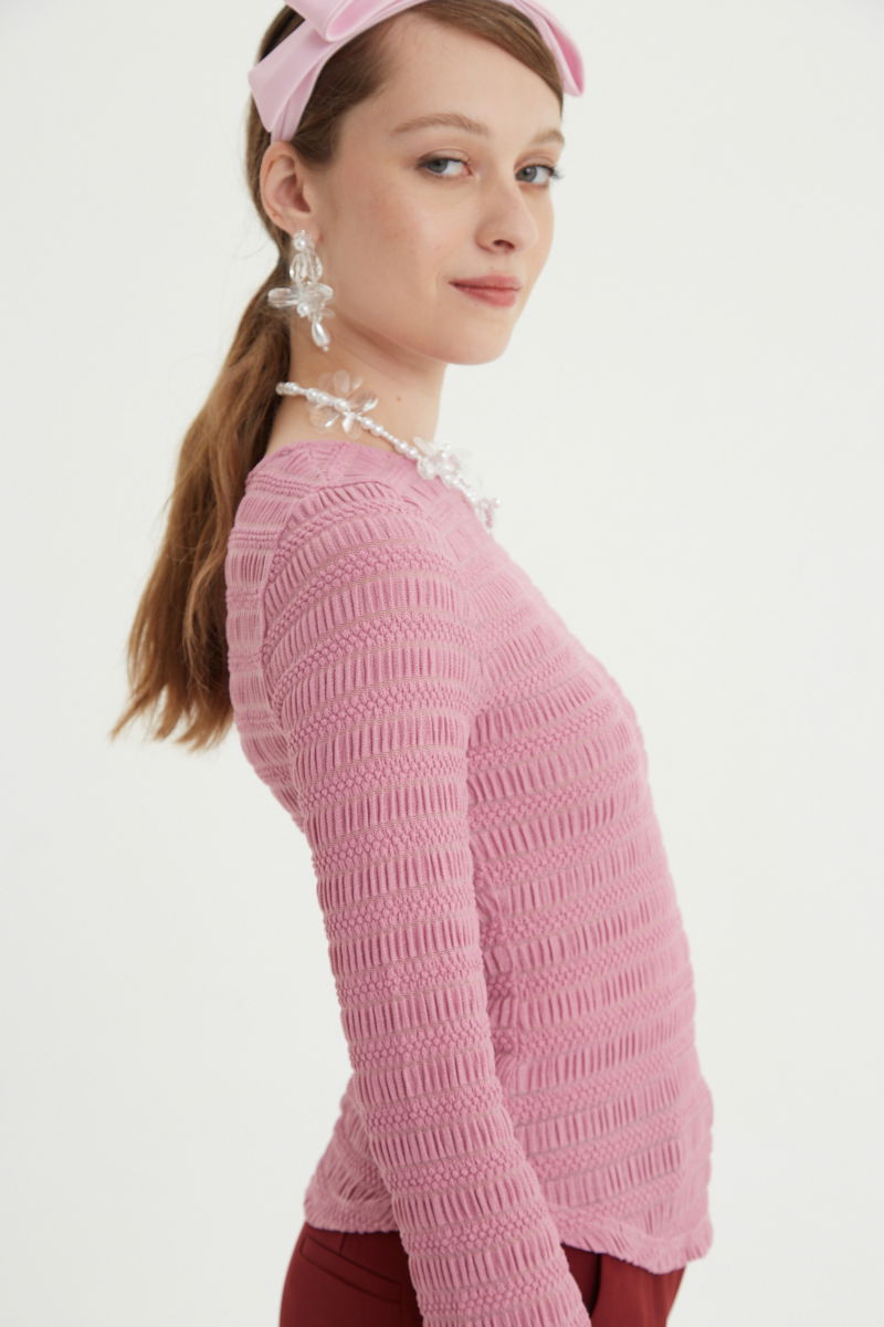 Remera rosa al cuerpo con mangas semi acampanadas, con escote a la base del cuello y textura fruncida. 
