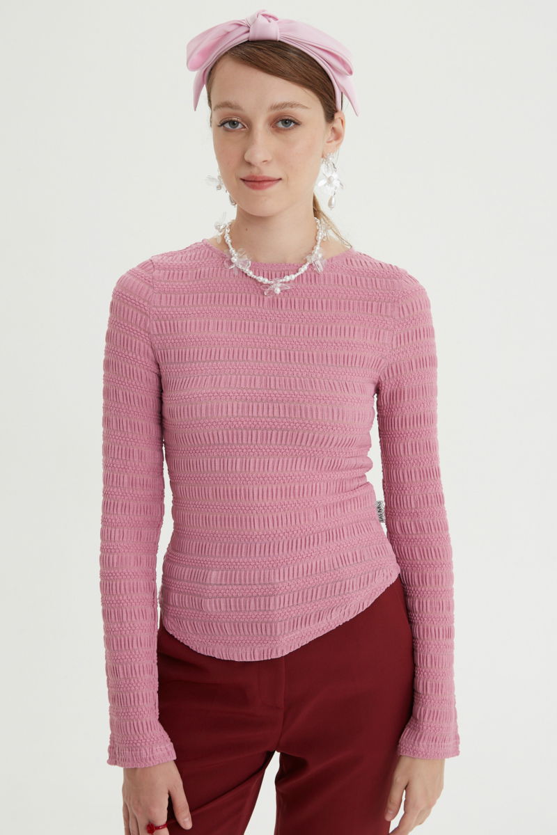 Remera rosa al cuerpo con mangas semi acampanadas, con escote a la base del cuello y textura fruncida. 
