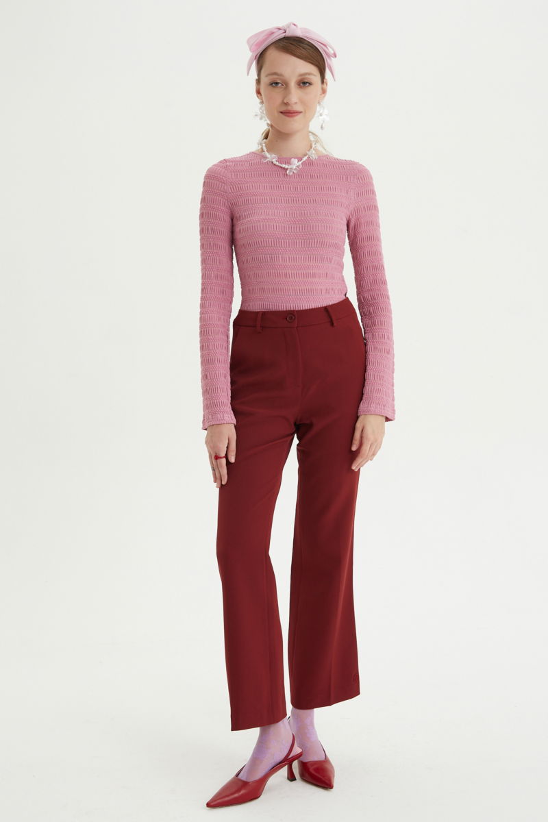 Remera rosa al cuerpo con mangas semi acampanadas, con escote a la base del cuello y textura fruncida. 
