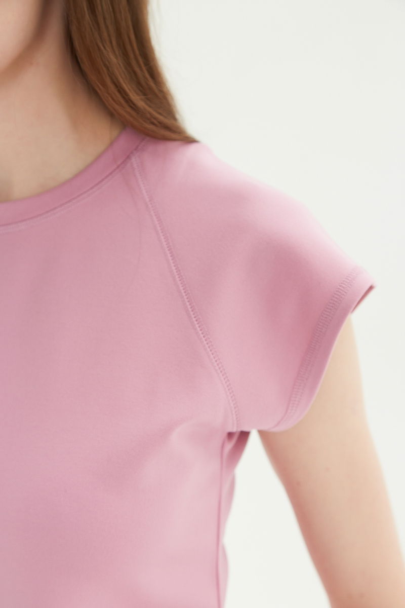 Remera rosa básica al cuerpo larga a la cadera con escote redondo y mangas cortas raglan. 
