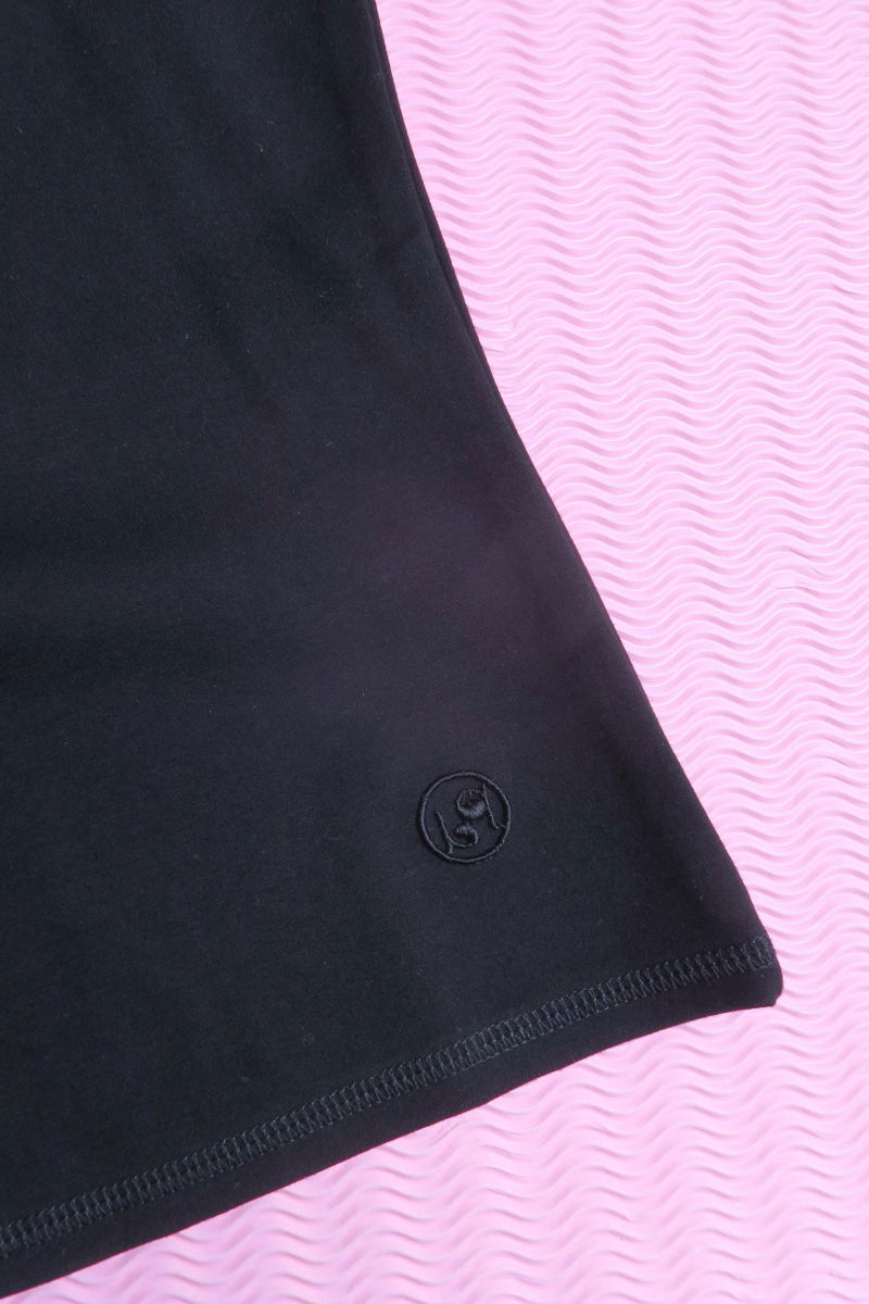 Remera negra básica al cuerpo larga a la cadera con escote redondo y mangas cortas raglan. 
