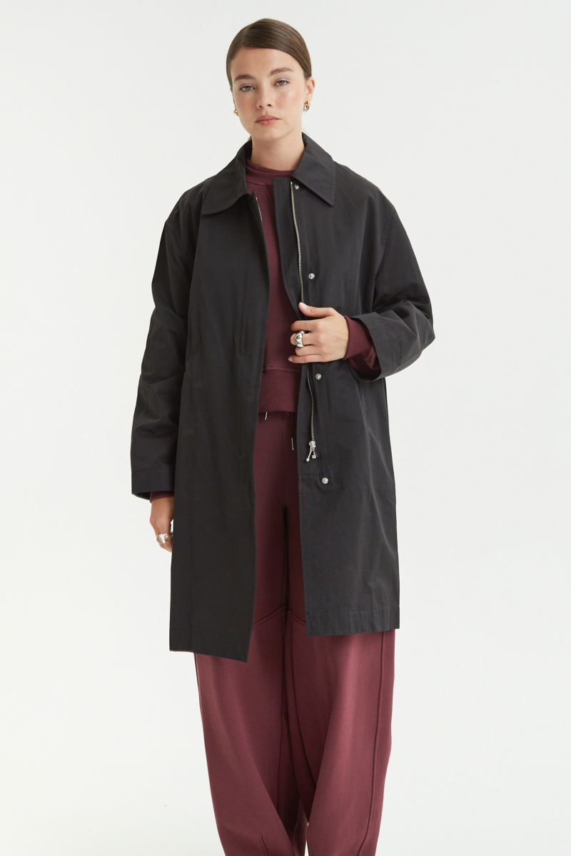 Saco negro liviano recto y largo por arriba de las rodillas con cierre, broches snap y cinturon. 
