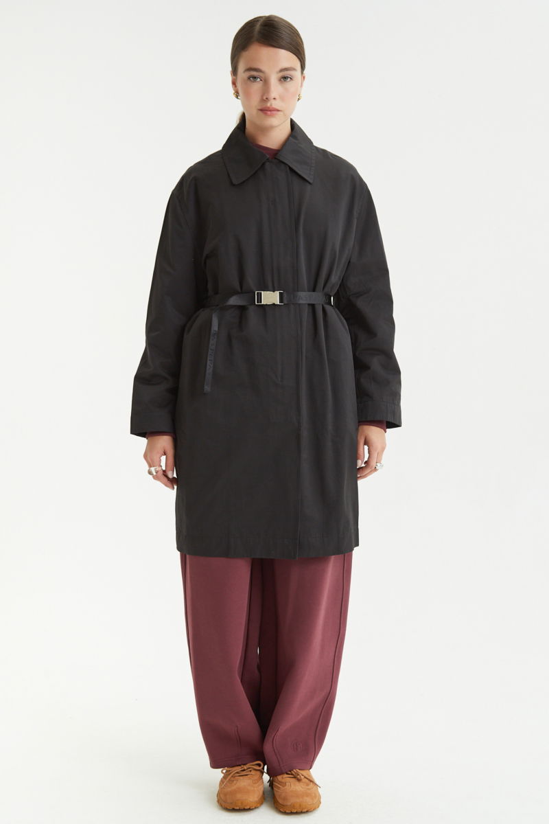 Saco negro liviano recto y largo por arriba de las rodillas con cierre, broches snap y cinturon. 
