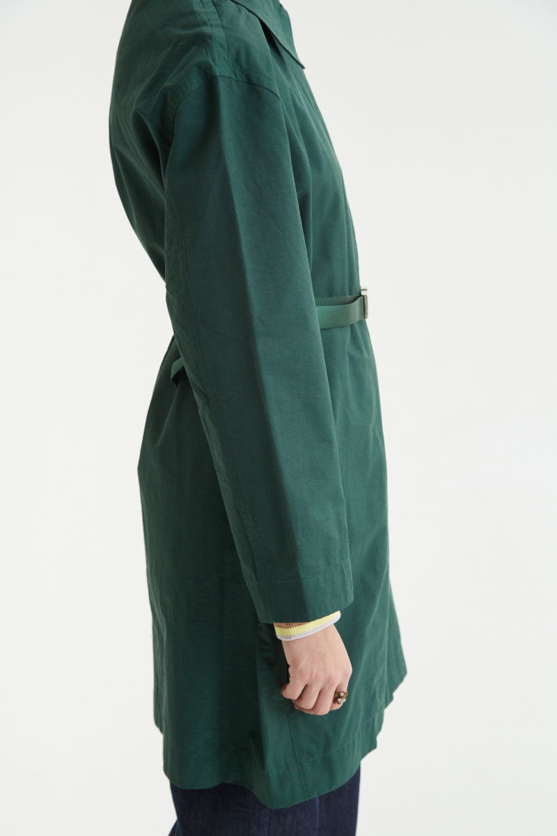 Saco verde liviano recto y largo por arriba de las rodillas con cierre, broches snap y cinturon. 
