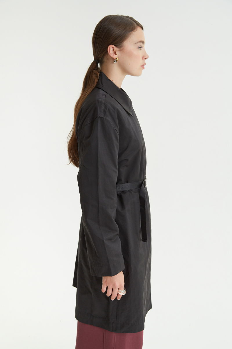 Saco negro liviano recto y largo por arriba de las rodillas con cierre, broches snap y cinturon. 
