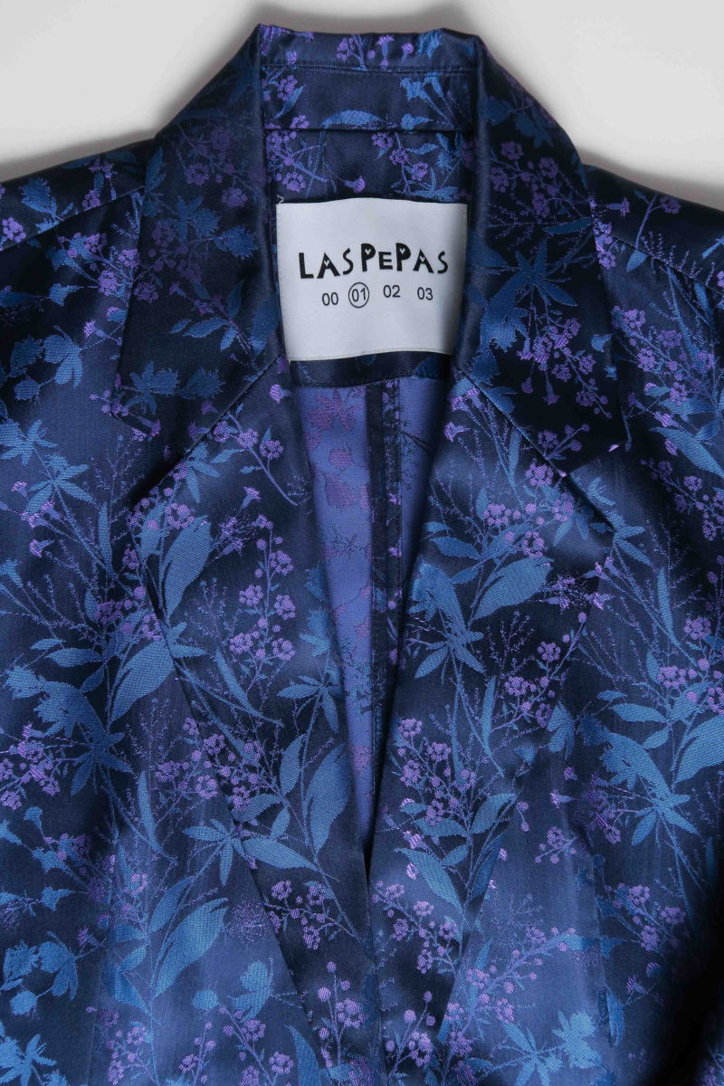 Saco azul sastrero recto de jacquard satinado con hombreras, solapa con cruce recto y botones tornasolados. 
