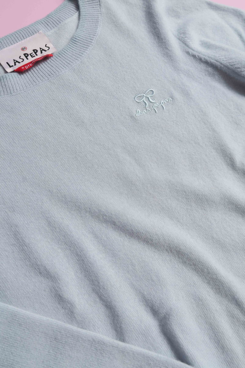 Sweater celeste de lana y cachemira recto y entallado en la cintura con cuello redondo y terminaciones de ribb en puños y ruedo.