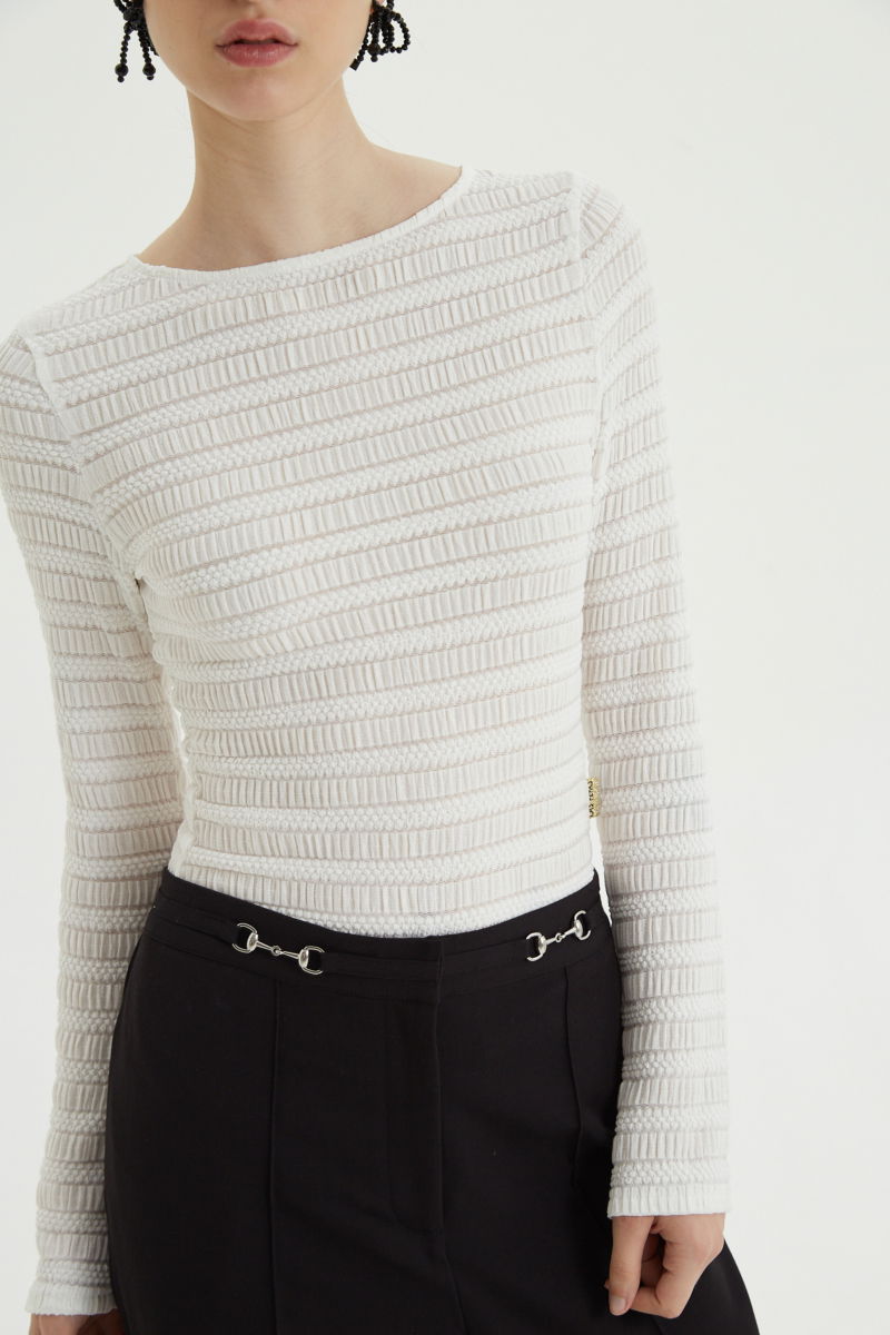 Remera blanca al cuerpo con mangas semi acampanadas, con escote a la base del cuello y textura fruncida. 
