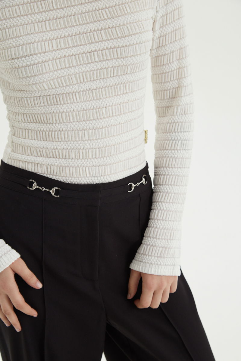 Remera blanca al cuerpo con mangas semi acampanadas, con escote a la base del cuello y textura fruncida. 
