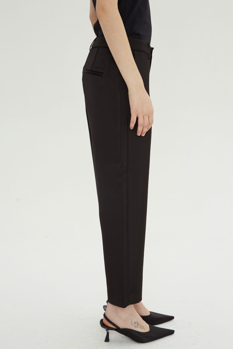 Pantalón negro sastrero satinado tiro medio de silueta recta y largo por encima del tobillo.
