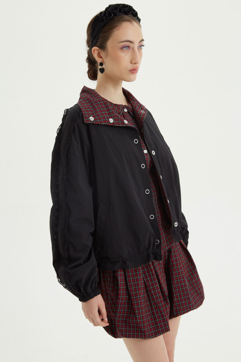 Campera reversible con puntilla y motivo de cuadros, cuello alto, broches snap y cintura con tancas. 
