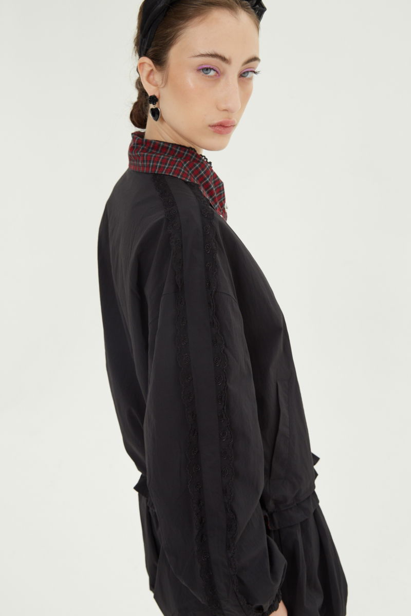 Campera reversible con puntilla y motivo de cuadros, cuello alto, broches snap y cintura con tancas. 
