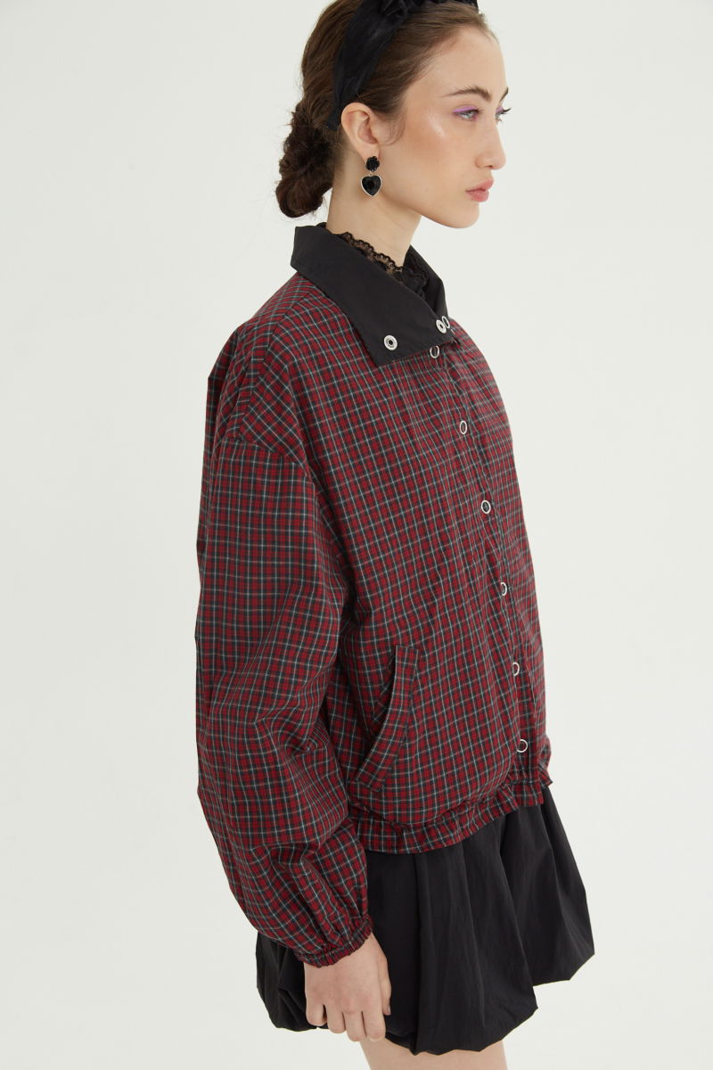 Campera reversible con puntilla y motivo de cuadros, cuello alto, broches snap y cintura con tancas. 
