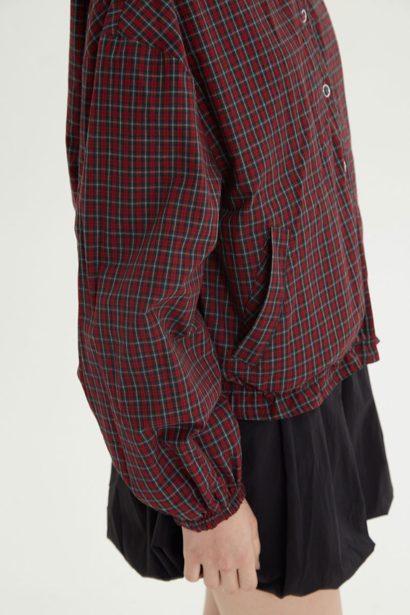 Campera reversible con puntilla y motivo de cuadros, cuello alto, broches snap y cintura con tancas. 
