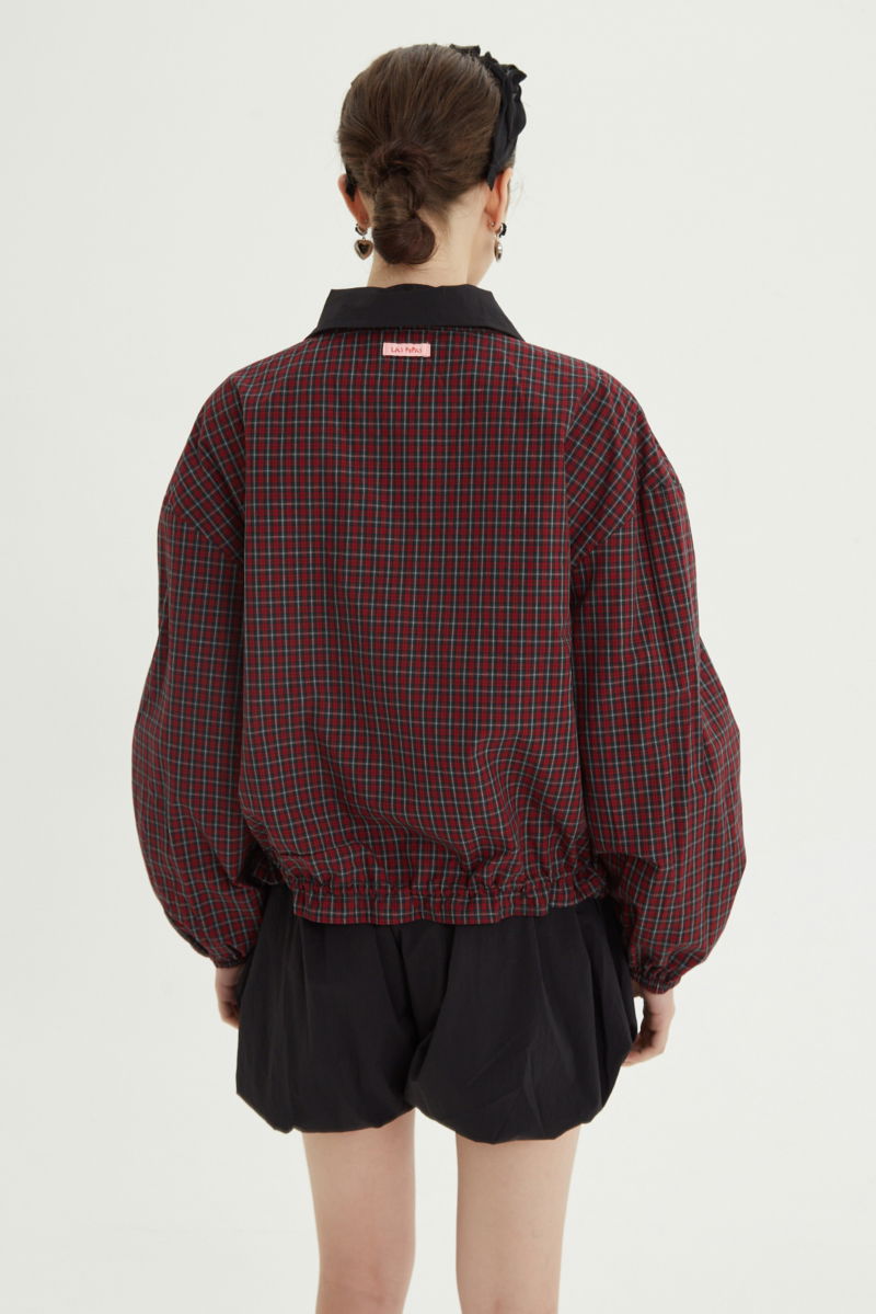 Campera reversible con puntilla y motivo de cuadros, cuello alto, broches snap y cintura con tancas. 
